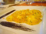 Ravioli ripieni di ricotta con salsa di zucca e scampi ed emulsione di nero di seppia